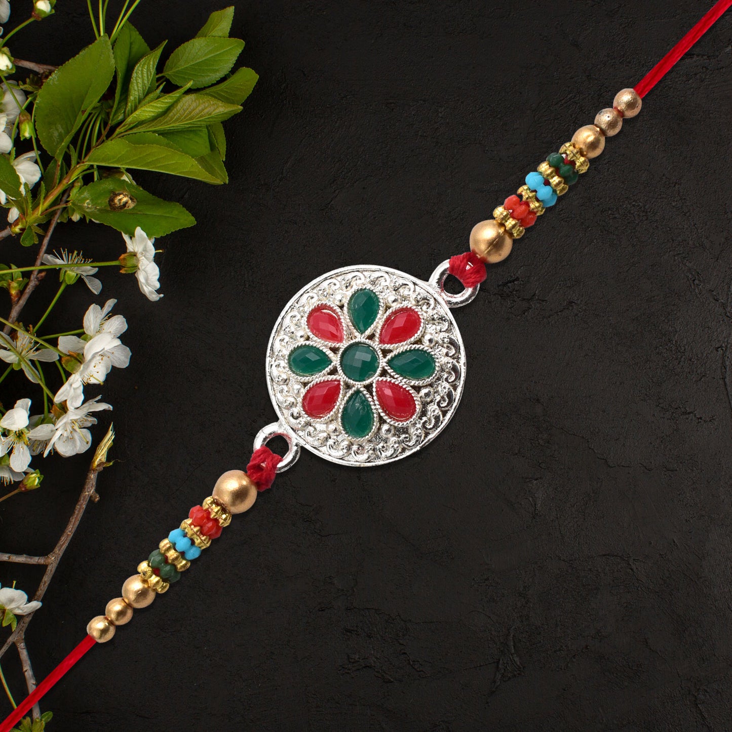 Silver Plated Floral Rakhi With Red Green Stones